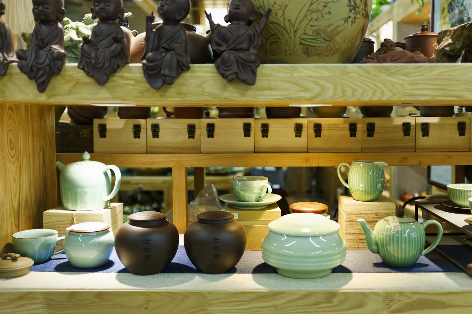 Etag&egrave;res de th&eacute;i&egrave;res et pi&egrave;ces en c&eacute;ramique dans un showroom lumineux